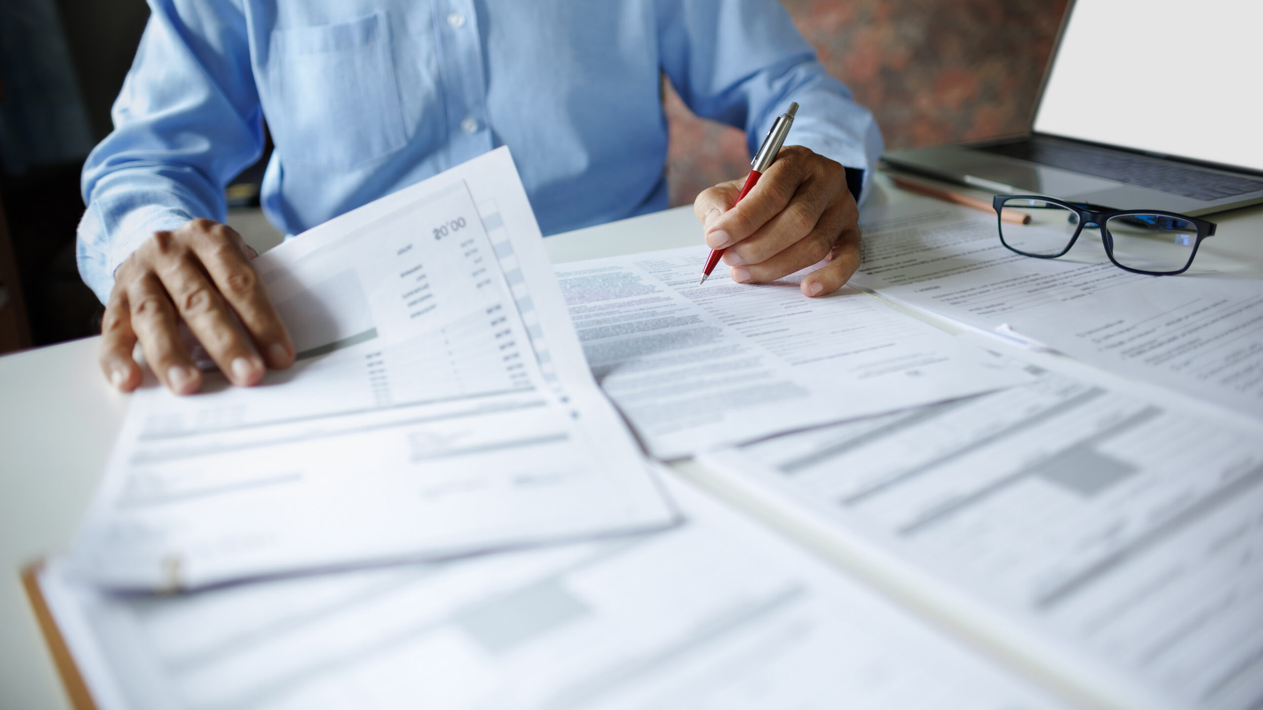 close up shot, accountant working with laptop reviewing the company's accounts and financial documents on desk