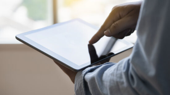 Digital tablet computer close up man using tablet hands man multitasking with isolated screen